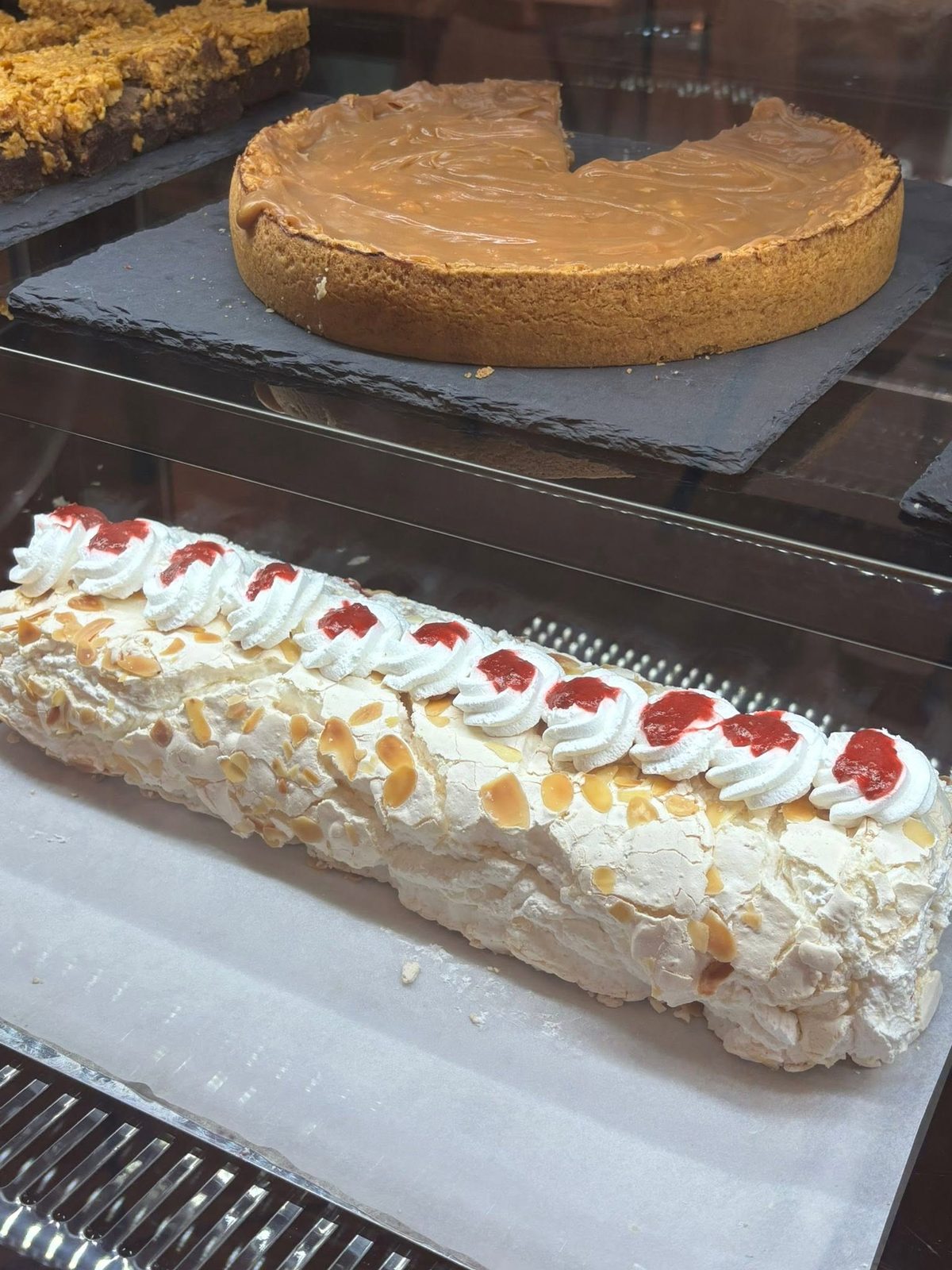 Caramel sponge cake and an almond meringue roulade in the display cabinet